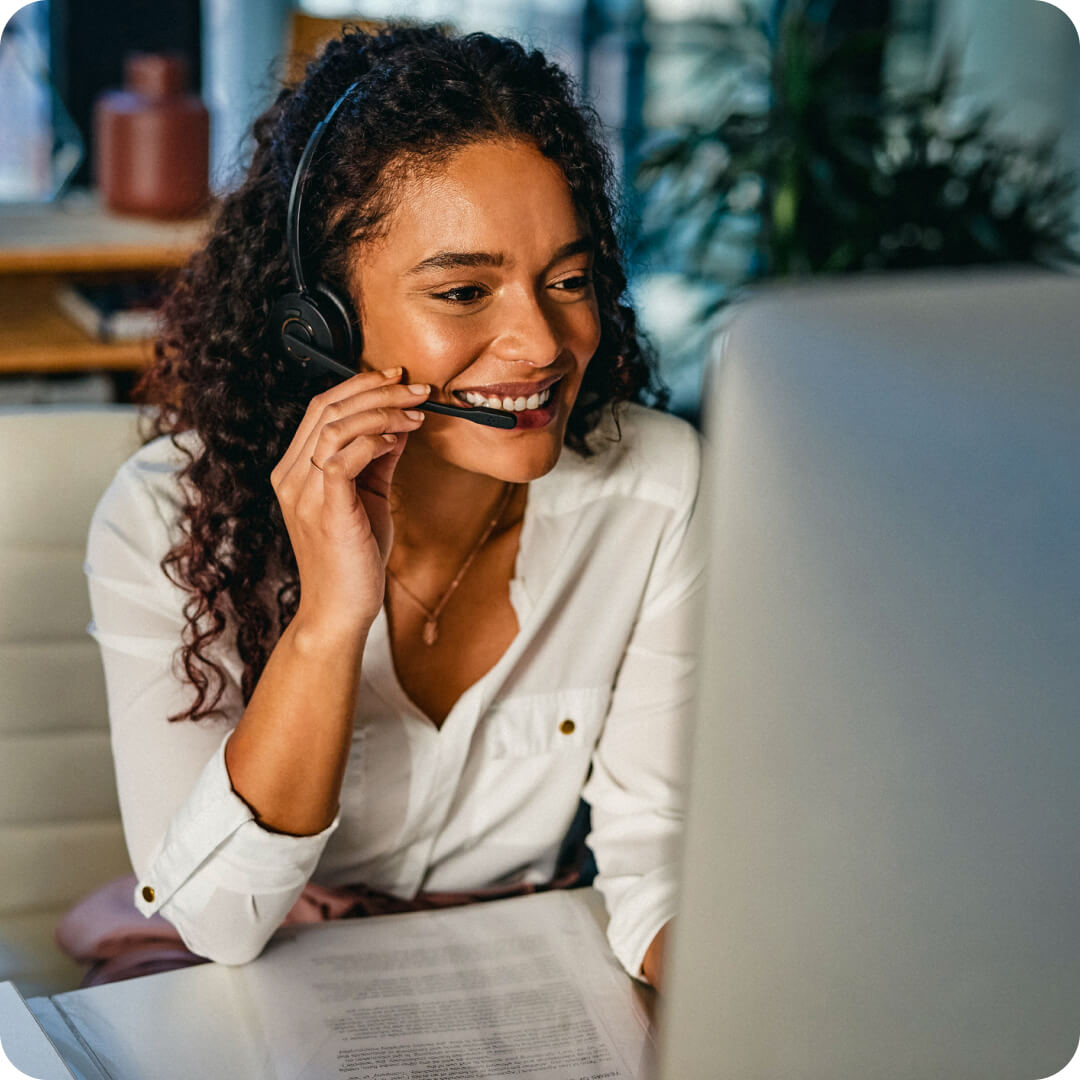 Smiling woman using headset to take call.