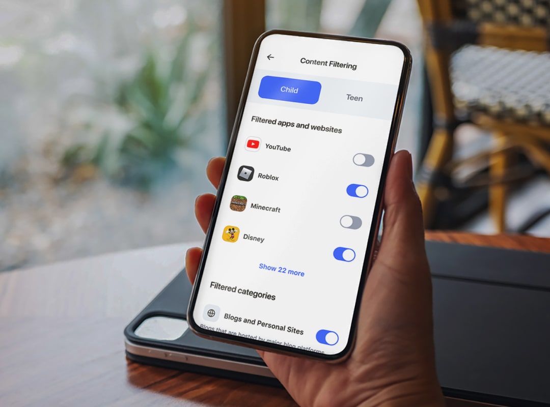 Person holding phone with Aura app. Text: Content Filtering. Child. Teen. Filtered apps and websites. YouTube. Roblox. Minecraft. Disney. Show 22 more.