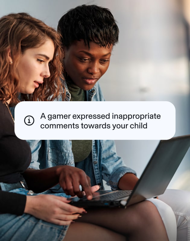 Two teenagers using a laptop, beside an Aura popup about cyberbullying that alerts guardians of threats within an online game