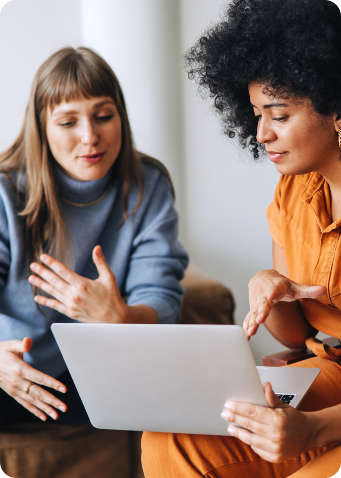 Female colleagues looking at laptop