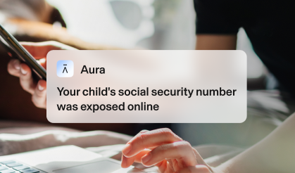 Zoomed-in hands using a laptop and phone. Text reads: Your child’s Social Security number was exposed online.