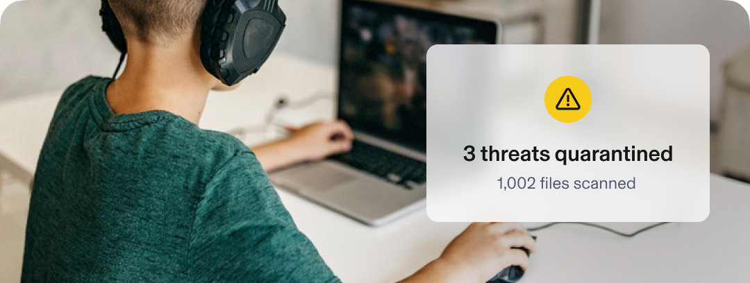 Child gaming on a laptop. Text reads: 3 threats quarantined, 1,002 files scanned.