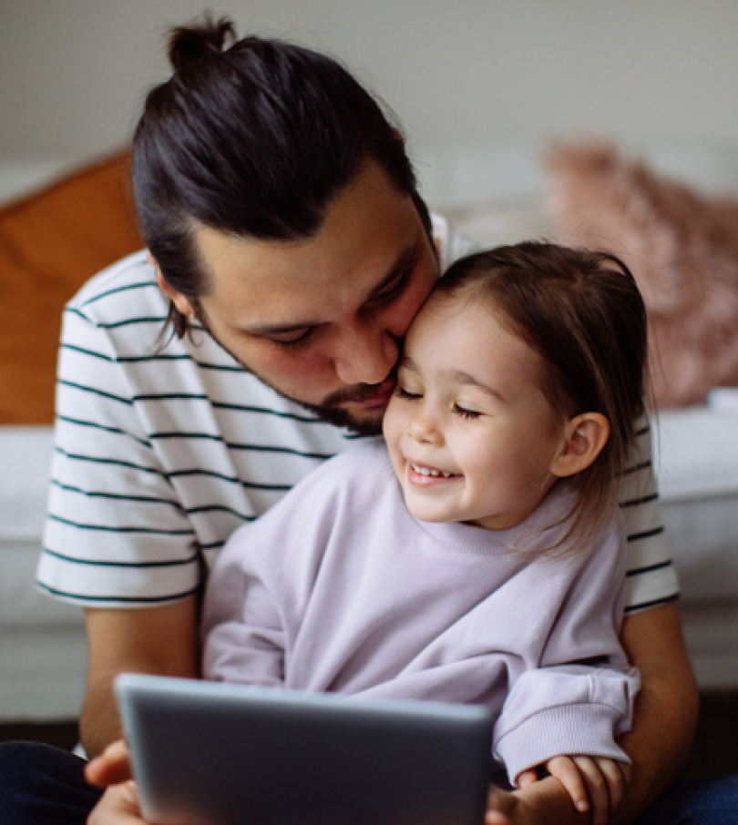 Father and daughter using a tablet facing the viewer
